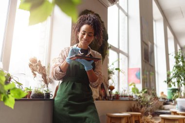 Woman florist takes care of seedlings in floral studio. Blurred background. High quality photo