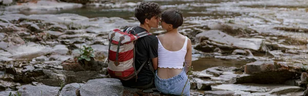 Kayalık Nehir Kıyısında Oturan Öpüşen Bir Çift Yürüyüşçünün Arka Görüntüsü — Stok fotoğraf
