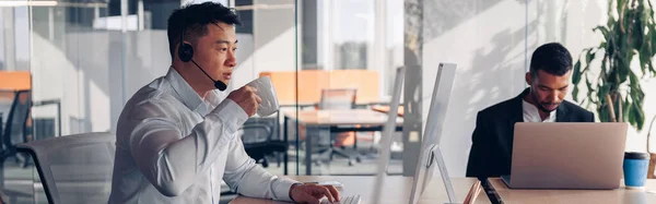Asiatischer Geschäftsmann Trinkt Kaffee Während Büro Computer Vor Dem Hintergrund — Stockfoto
