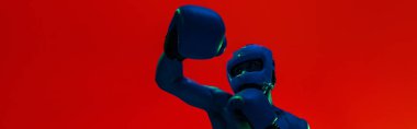 Man wearing head guard and boxing gloves practicing for fight on studio background with color filter