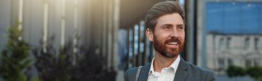 Smiling Businessman going home after long working day and using phone. Blurred background