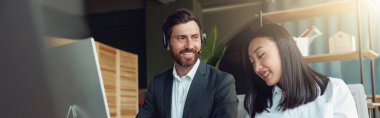 Two people working in a modern office and discussing a new project. Blurred background