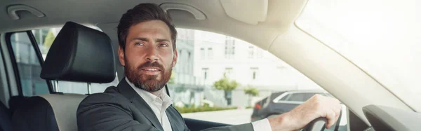 Handsome Businessman Grey Suit Riding Steering Wheel Car Blurred Background — Stock fotografie