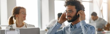 Businessman working laptop while sitting in modern office on colleagues background. Business concept