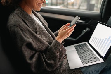 İş kadını laptopta çalışıyor ve iş yerine giderken de telefonu kullanıyor. Yüksek kalite fotoğraf