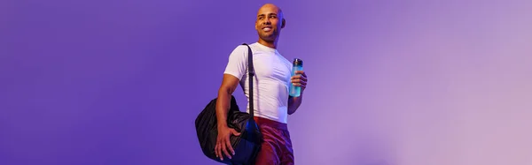 Athlete Holding Water Bottle Bag Looking Side Studio Background Violet — Stok fotoğraf