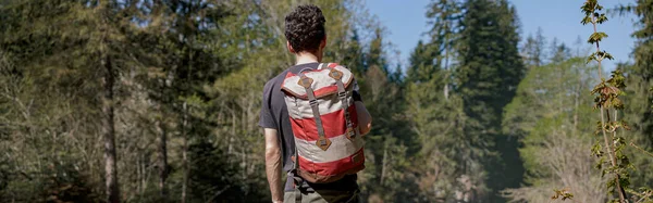 背负背包站在悬崖上的男性游客的背景图 徒步旅行 — 图库照片