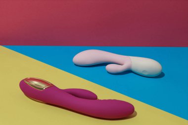 Two dildo vibrators on colored background with shadows. Sex toy for adult. High quality photo