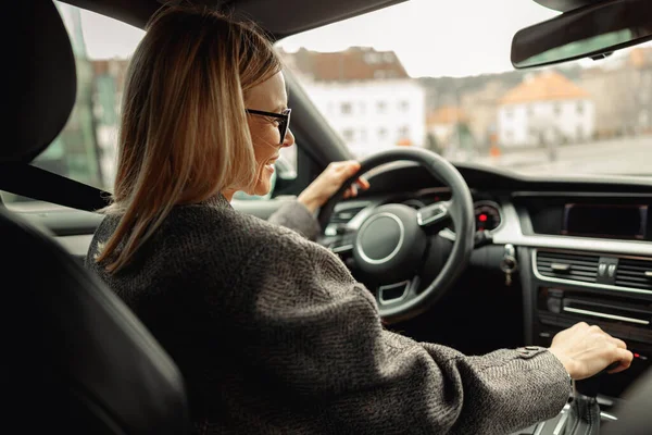 Pengusaha Wanita Berkacamata Mengemudi Mobil Dengan Satu Tangan Roda Kemudi — Stok Foto