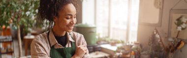 Smiling woman florist standing in floral studio during working day. High quality photo