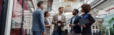 Businesspeople talking while standing in office during break. Teamwork concept. High quality photo