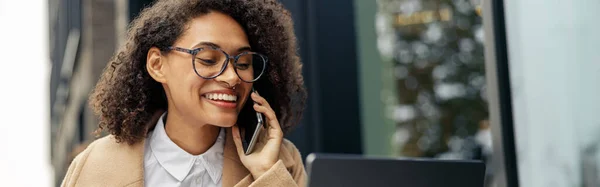 stock image Businesswoman talking phone while working online sitting in cafe terrace. High quality photo