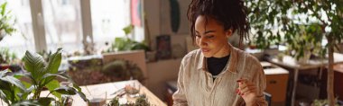 Florist woman works in her small floral business surf for information about plants using laptop