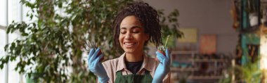 Woman florist takes care of seedlings in floral studio. Blurred background. High quality photo