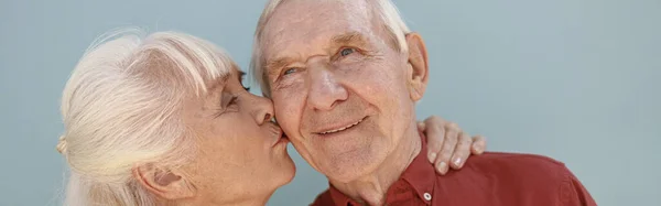 Blonde Mature Woman Kisses Loving Man Partner Standing Light Grey — Stock Photo, Image