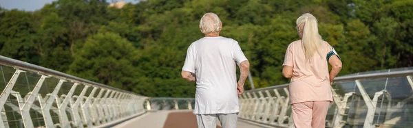 穿着运动服的活泼的老年男女在夏日后视镜下沿着人行天桥跑步 积极的生活方式和保健 — 图库照片