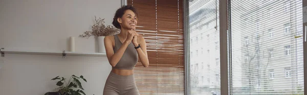 Stock image Afro american woman doing exercises for legs by online tutorials on laptop at home