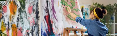İlham verici kadın, önlüklü kadın sanatçı ev stüdyo atölyesinde soyut resim yapıyor. Sanat, hobi, eğlence konsepti