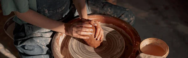 陶磁器工房では 女性陶芸家が陶芸ホイールで回転する粘土製のクロックを形成する角度の高い風景 — ストック写真