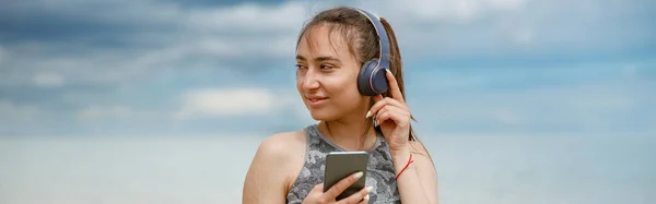 Junge Frau Sportkleidung Hört Musik Über Kopfhörer Strand Vor Dem — Stockfoto