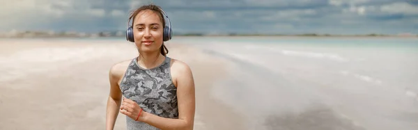 Молода Спортивна Жінка Навушниках Бігає Над Морем Вранці Пляжі Концепція — стокове фото