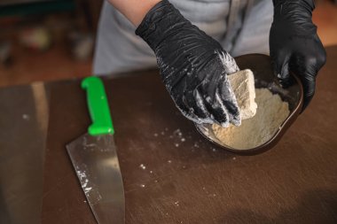 Şef, restoran mutfağında tavada kızarmadan önce peyniri una bular. Yüksek kalite fotoğraf