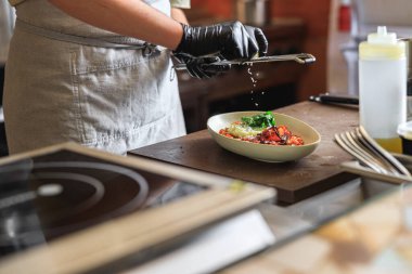 Profesyonel şef, restoran mutfağında parmesan peyniri rendeliyor. Yüksek kalite fotoğraf