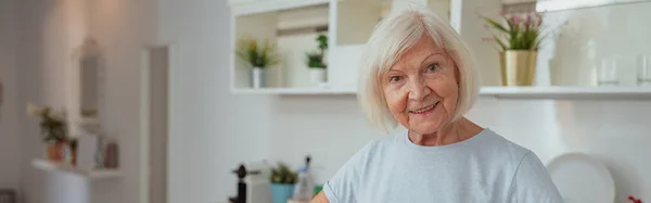 Glückliche Seniorin Lächelt Die Kamera Während Sie Der Heimischen Küche — Stockfoto
