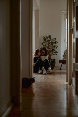 Kadın ve erkek, oturma odasında sevgi ve şefkatle sarılıyorlar. İyi ilişkiler zamanı.