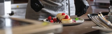 Şef, restoranın mutfağında kahvaltıda böğürtlenli cheesecake hazırladı.