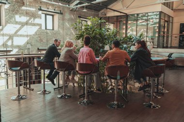 Birlikte çalışan ve modern ofiste konuşan bir grup iş arkadaşı. Birlik kavramı