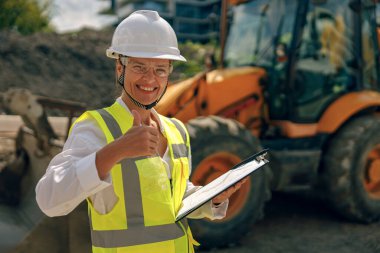 İnşaat geçmişine karşı koruyucu kask takan profesyonel kadın mühendis. 