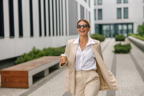 Wanita Tersenyum Pekerja Kantor Dengan Kopi Berjalan Atas Latar Belakang — Stok Foto
