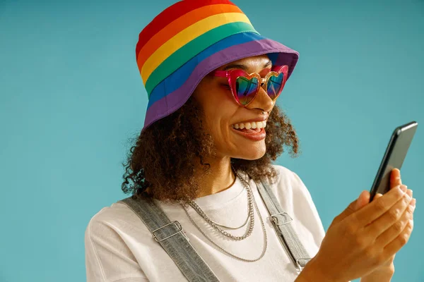 Wanita Ceria Dengan Topi Pelangi Sedang Melihat Ponsel Berdiri Atas — Stok Foto