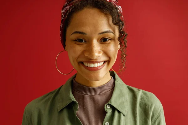 Portret Uroczej Kobiety Wygląda Aparat Fotograficzny Uśmiechem Stojący Czerwonym Tle — Zdjęcie stockowe
