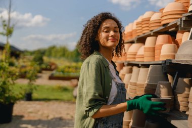 Boş saksılarla dolu rafların arkasında duran kadın bahçıvan. Yüksek kalite fotoğraf