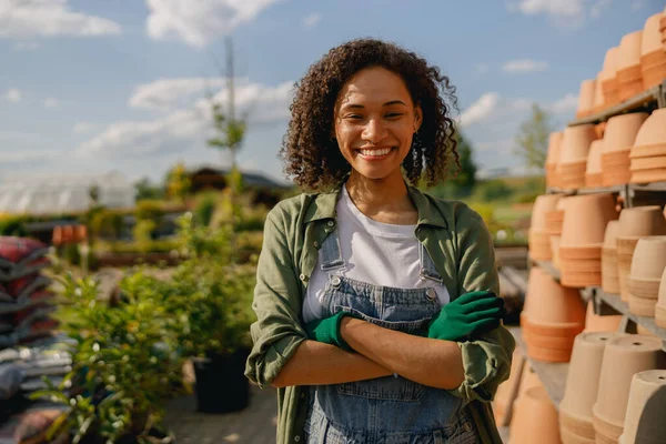 Boş saksılarla dolu rafların arkasında duran kadın bahçıvan. Yüksek kalite fotoğraf
