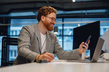 Erkek girişimci, modern ofiste çalışırken telefonla görüşüyor. Yüksek kalite fotoğraf