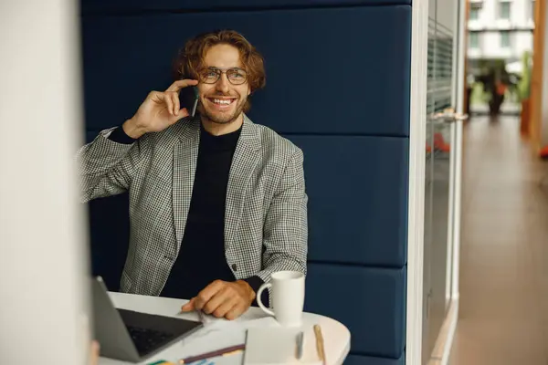 Forretningsmann Snakker Telefon Med Klienten Mens Sitter Coworking Jobber Laptop – stockfoto