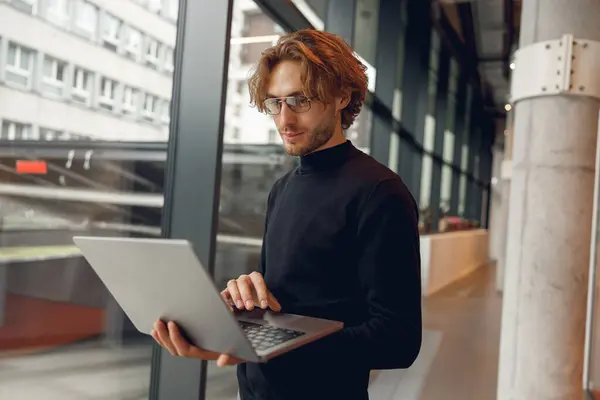 Pengusaha Gaya Yang Bekerja Pada Laptop Sambil Berdiri Pada Latar — Stok Foto