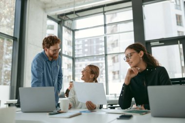 Bir grup farklı insan ofis toplantı odasında yeni projeyi tartışıyor. İş takım çalışması durumu