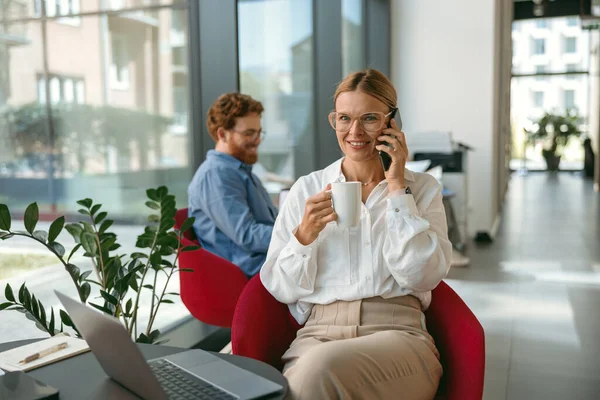 Pengusaha Wanita Berbicara Telepon Dengan Klien Saat Bekerja Pada Laptop — Stok Foto