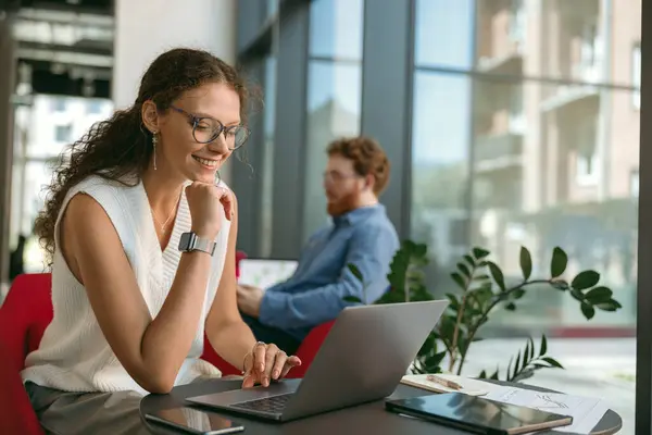 Lächelnde Unternehmerin Arbeitet Laptop Während Sie Modernen Coworking Sitzt Stockfoto