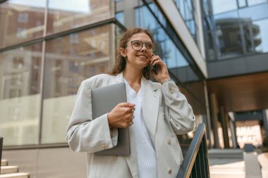 Ofis geçmişinde dizüstü bilgisayarı olan şık bir iş kadını.