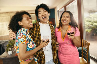 Mutlu arkadaşlar şarap içip bardaklarını tokuşturarak evde tatil partisi veriyorlar. 