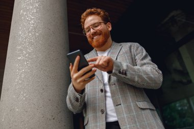 Mola sırasında ofisin yanında duran yakışıklı serbest çalışan bir erkek.