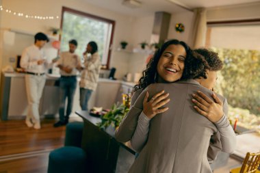 Gülümseyen arkadaşlar sarılırlar ve tatilde birlikte vakit geçirmenin tadını çıkarırlar.