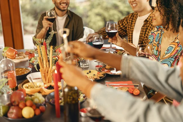 Group of friends enjoying in conversation and drinking wine during Christmas party at home