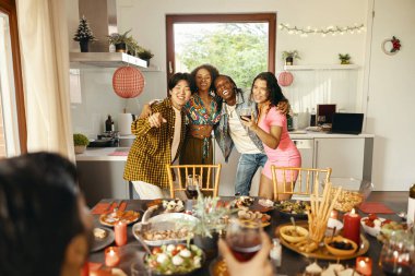 Neşeli bir grup genç arkadaş parti sırasında evde içki içip dans ediyorlar.