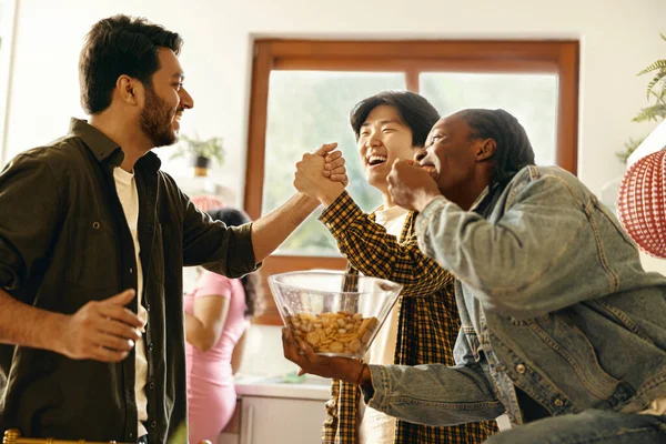 Happy friends giving high five greeting each other at home party. High quality photo